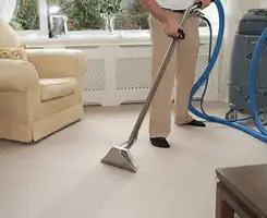 Carpet cleaning professional removing dirt and stains with a hot-water extraction tool in a home, West Palm Beach, FL.